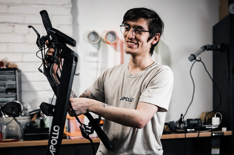 Apollo Scooters certified technician smiling while servicing e-scooter