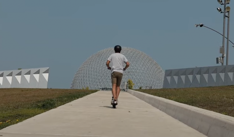 Sean riding his scooter towards the iconic Montreal Biosphere.