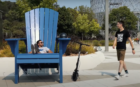 Sean sitting on a huge blue chair and waiting for Simon.