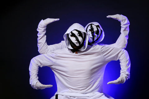 Two Dancers on white clothing wearing black and white makeup