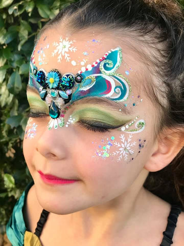 beautiful girl face painted with blue paint with glitter. Stock