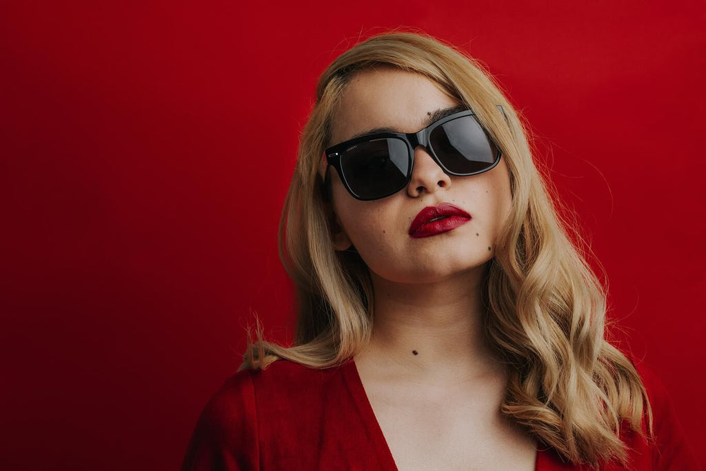 Woman posing with bold sunglasses and red lipstick