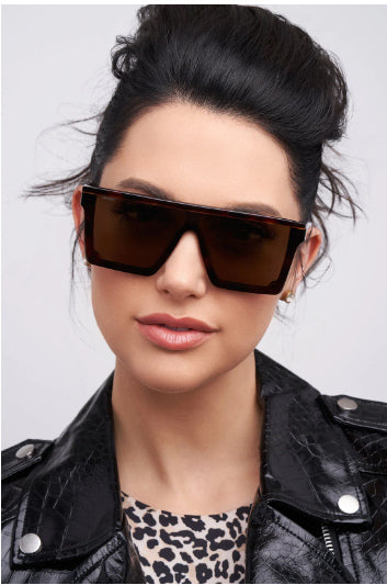 woman in a leather jacket and square oversized sunglasses