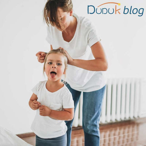 mamá ayudandole a su hija con el cuidado de su cabello