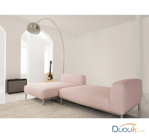 minimalismo japónes en sofa rosa con muro blanco y lampara curveada