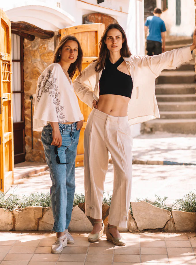 Two women posing stylishly in a courtyard, wearing Toni Pons Wedge Espadrilles