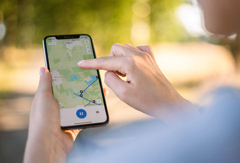 The hands of someone holding and using a phone for navigation.