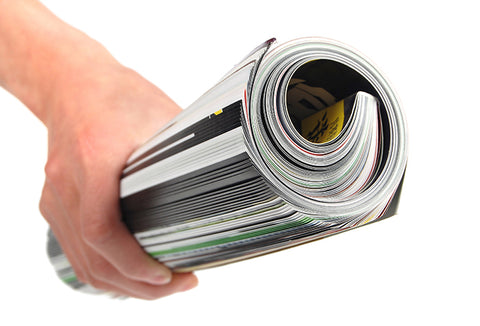 A person holding a rolled up magazine.