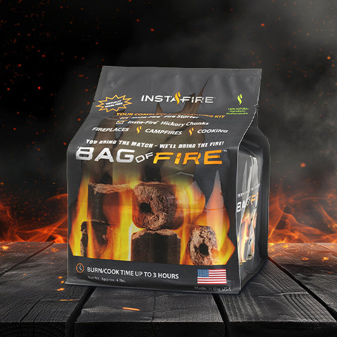 InstaFire Bag of Fire sitting on wood table with flames surrounding it in the dark.