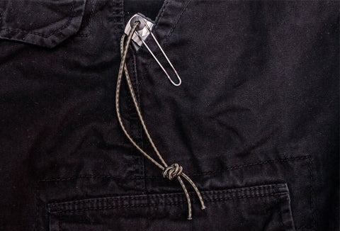 Pocket knife clipped and tied to the inside of a pants pocket.