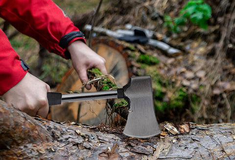 Person cutting branches off of a fallen tree.