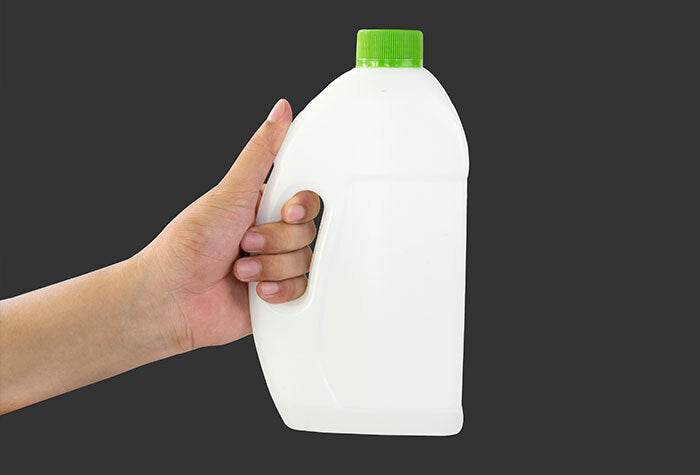 hand holding empty plastic jug