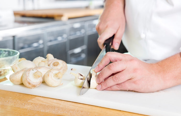 chef cutting fresh mushrooms