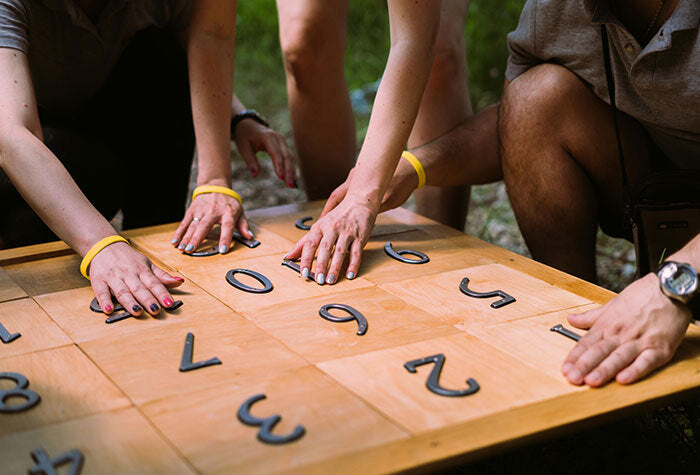 A group of people working out a puzzle game together in the outdoors.