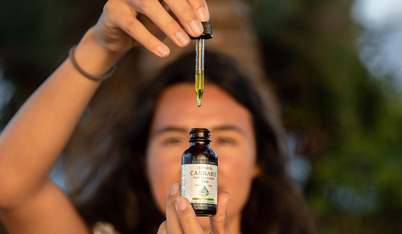 Women holding CBD oil and wondering about the benefits of CBD