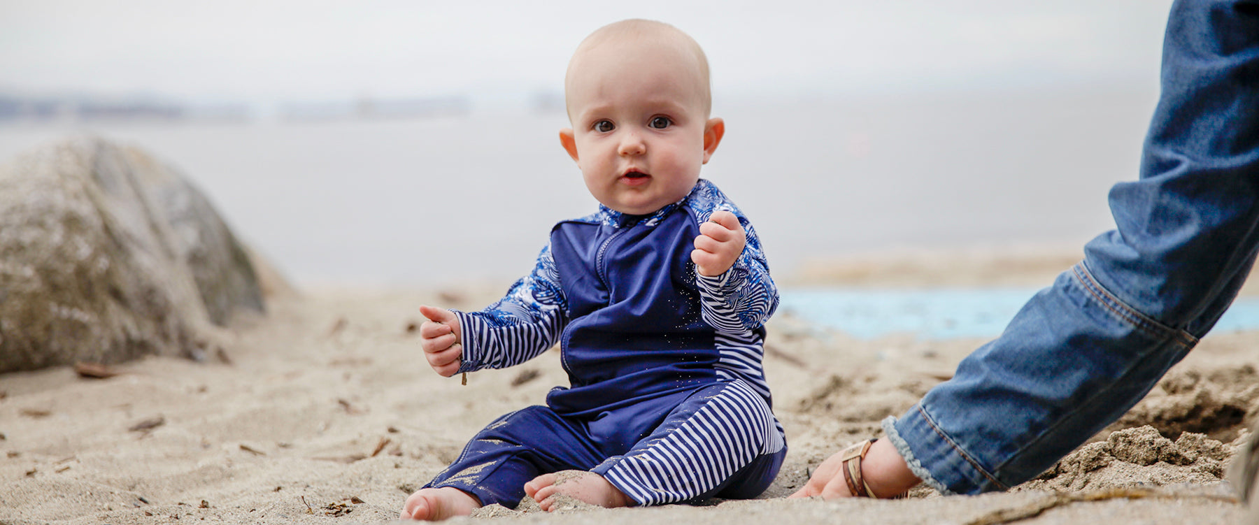 Little baby wearing Stonz UV protection sunsuit at the beach