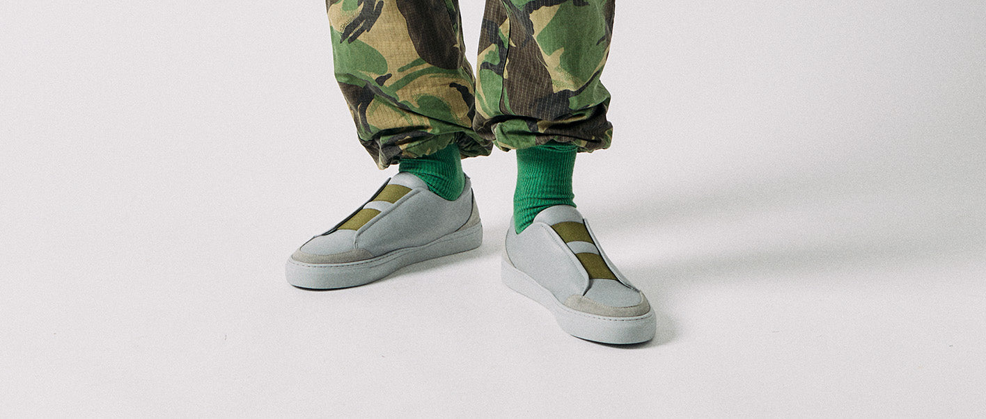 Un homme portant un pantalon de camouflage et des chaussures basses personnalisées sneakers.