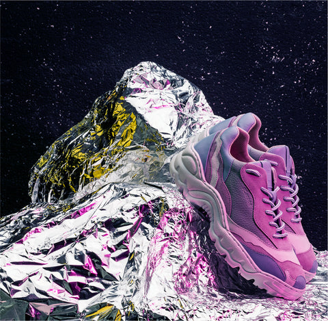 Une paire de sneakers roses au-dessus d'un rocher dans la lune.