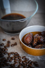 A cup of Medjool dates and coffee beans