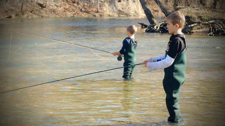 Two kids fly fishing