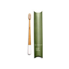 White tipped bamboo toothbrush with green cardboard pillow packet.