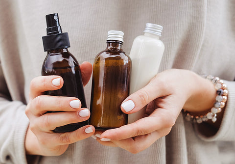 person holding glass jars and bottles.