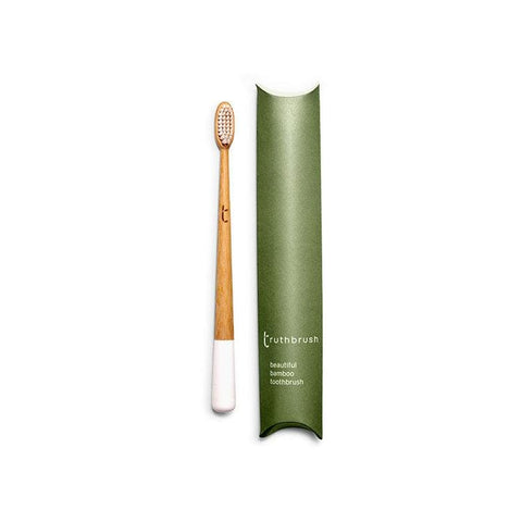 bamboo toothbrush next to cardboard packaging.