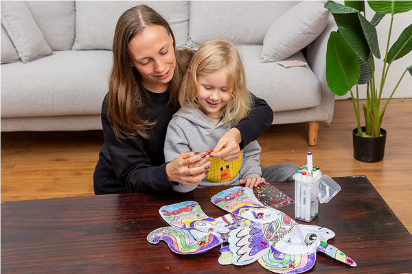 Mom and daughter sitting at a table coloring the unicorn craft