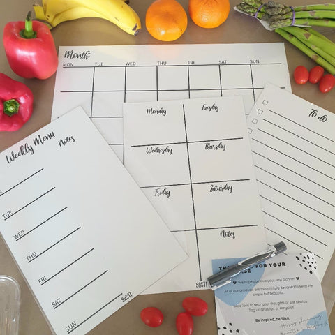Magnetic planners laid out on table with fruit and vegetables