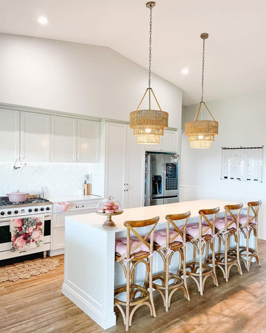 beautiful kitchen with Siisti on the wall (and fridge) with pink donuts on the kitchen bench