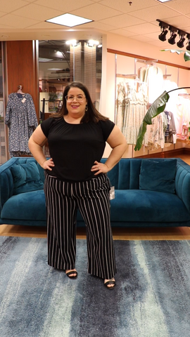 PHOTO OF NICHOLE IN HABITAT BLACK AND WHITE STRIPED FLOOD PANTS AND A BLACK SATIN TEE