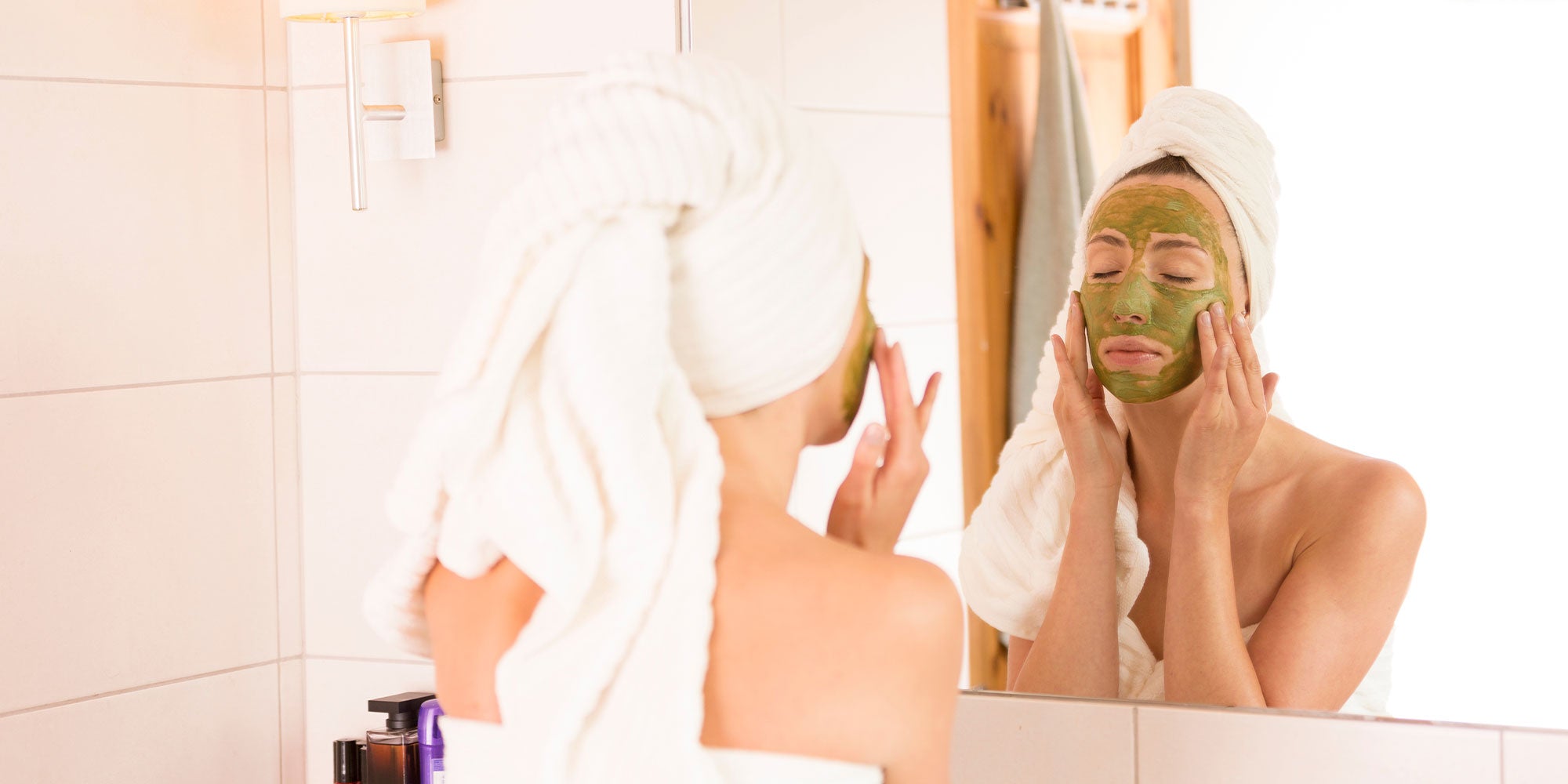 Woman putting on a green tea clay mask
