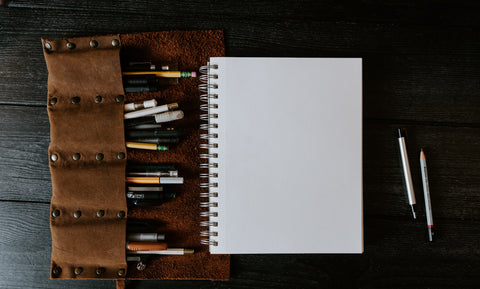 pens and pencils with a notebook