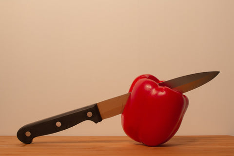 a knife and a pepper on a table