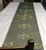 Mistletoe table runner on white tablecloth.