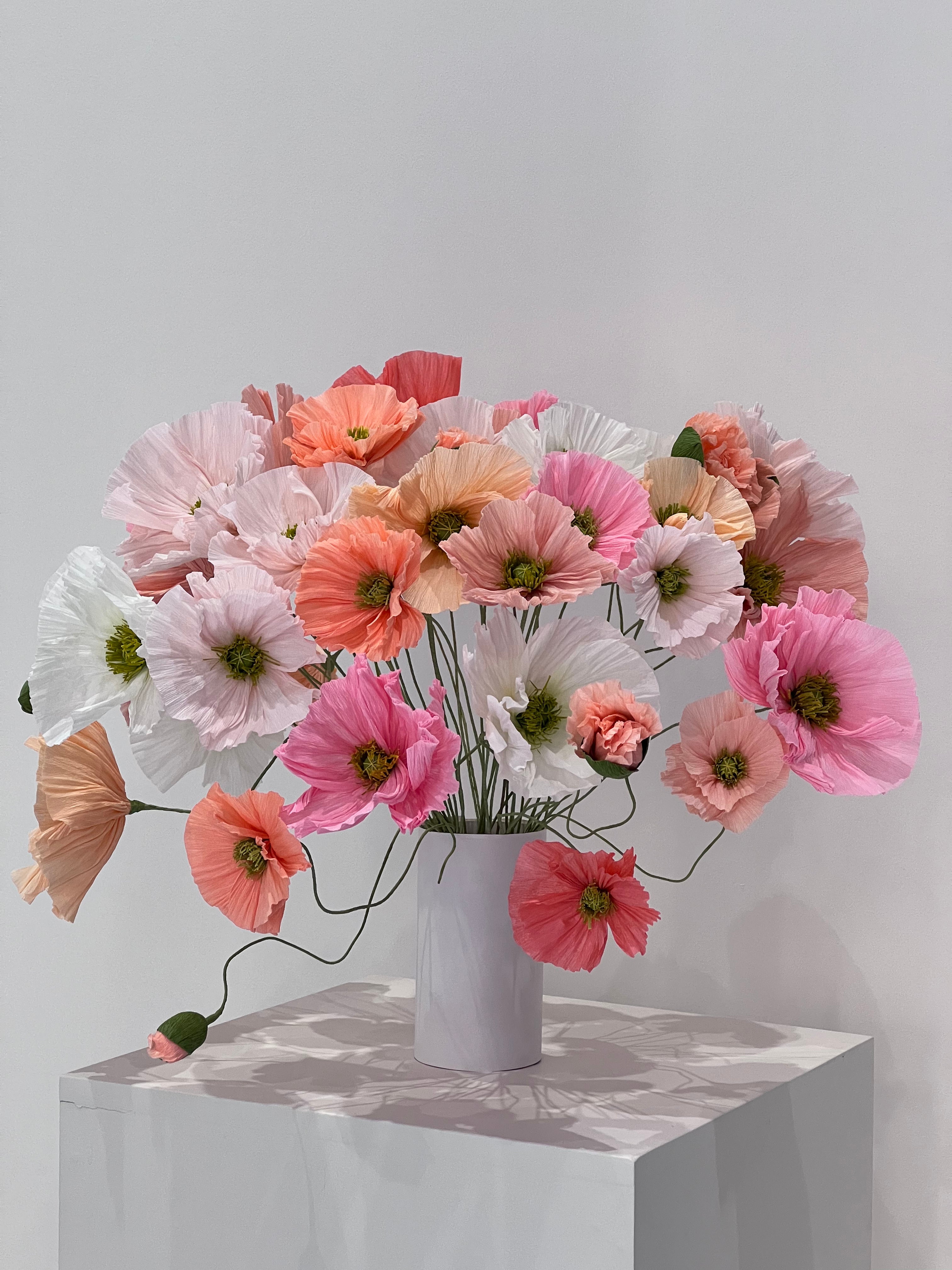 Paper poppies artfully arranged in a cascading formation, creating a sense of movement and grace.