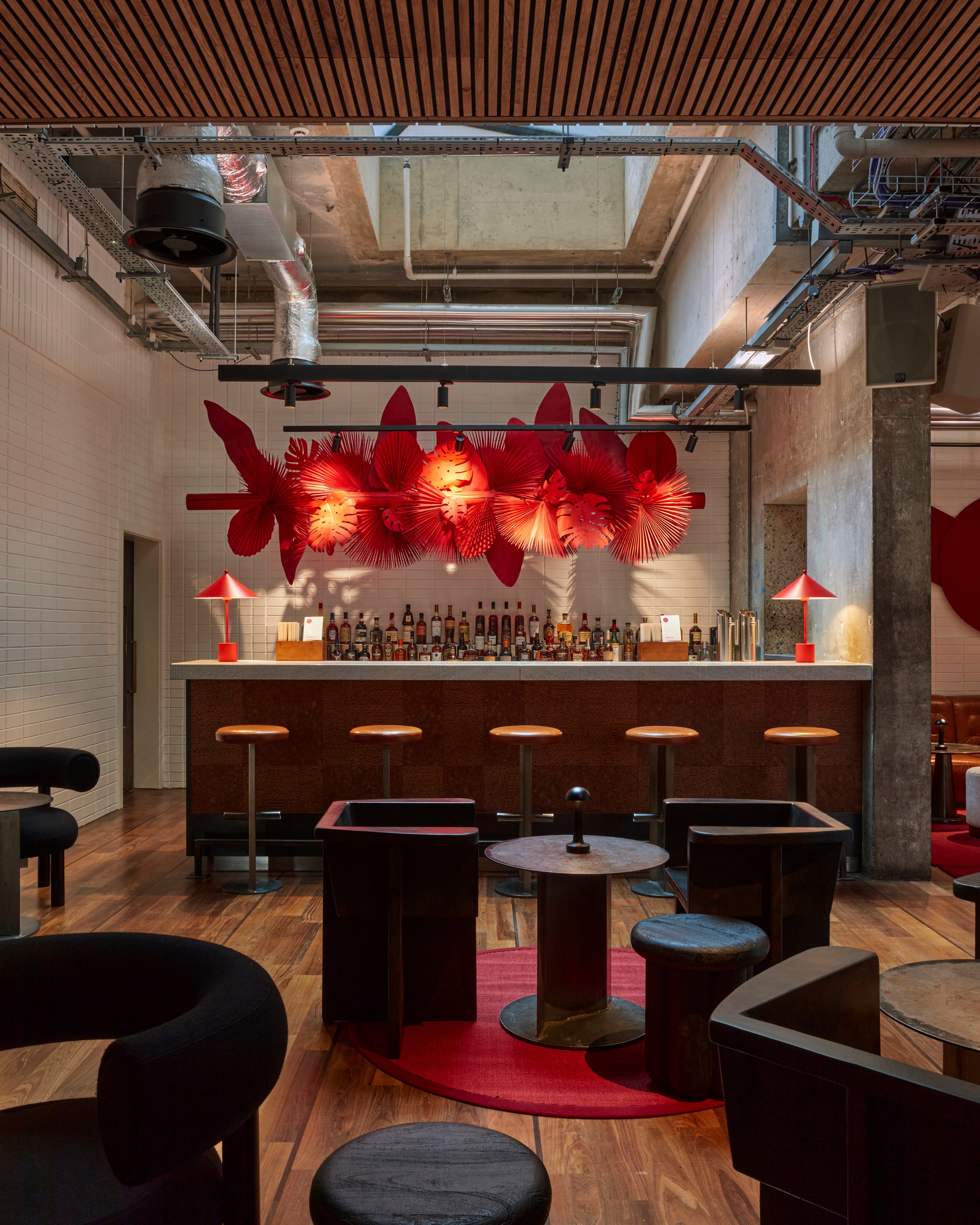 The striking centerpiece of the Lobby Bar at One Hundred Shoreditch Hotel, an impressive giant paper artwork in flamboyant red, adorned with intricately crafted tropical leaves.