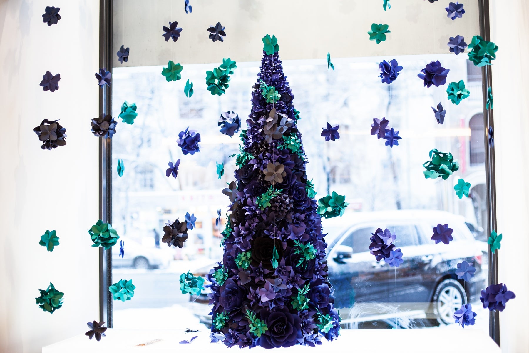 Stunning paper flower Christmas tree with a vibrant color palette of ultramarine blue and turquoise blue, complemented by hanging paper hydrangeas.