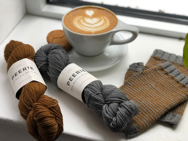 Merino wool yarn Peerie laying by hand knit gloves and a delicious latte in a mug