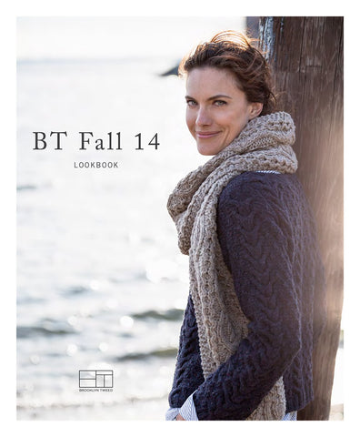 A woman stands on a dock over water modeling a hand knit wool pullover with a hand knit wool scarf. Title reads "BT Fall 14 Lookbook"