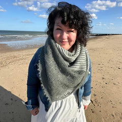Anna Nikipirowicz on a beach wearing a beautiful hand-knitted shawl