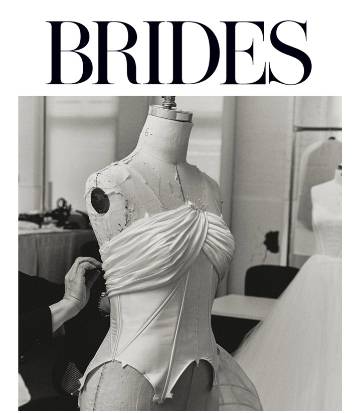 White wedding dress bodice on a mannequin being sewn by seamstress