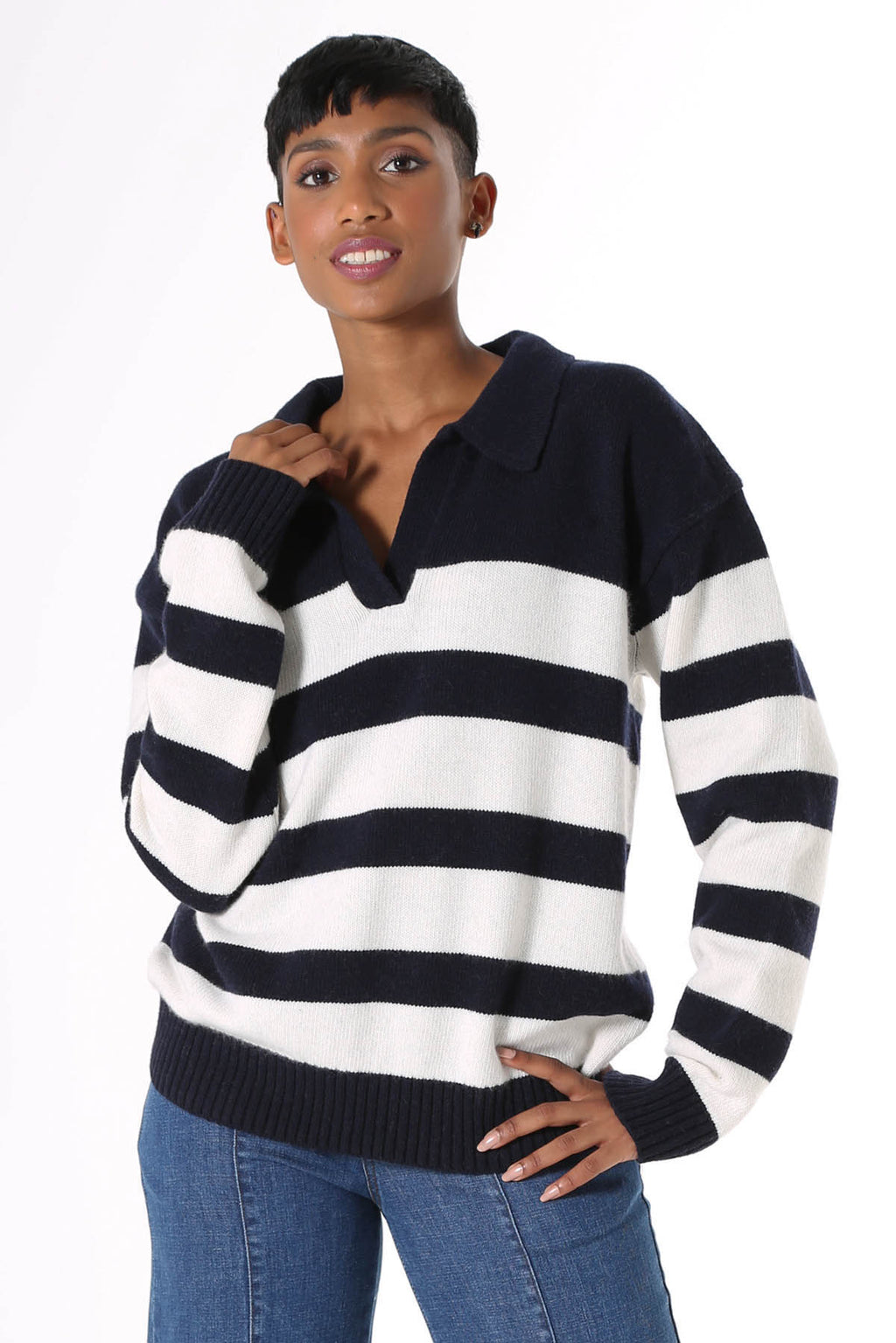 Olga de Polga Coota Long Striped Sweater. Blending the relaxed fit of a polo sweater with the luxury of cashmere, this is the perfect weekend knit. Long length that falls below the hip, relaxed fit, with an open collar, v-neck and dropped shoulder. Patterned with wide and narrow horizontal navy stripes. 