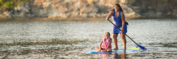 woman and child on stand up paddle board