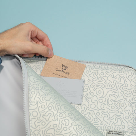 Male hand placing business card into the business cardholder, inside the grey 13-inch Eco-Conscious Laptop Sleeve