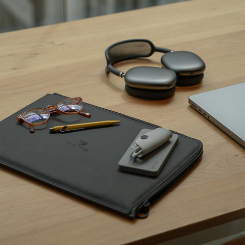 Miho Black eco laptop sleeve on a desk in a co-working space