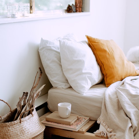 A cozy relaxing bed for sleeping with neutral tones on pillows and blankets 