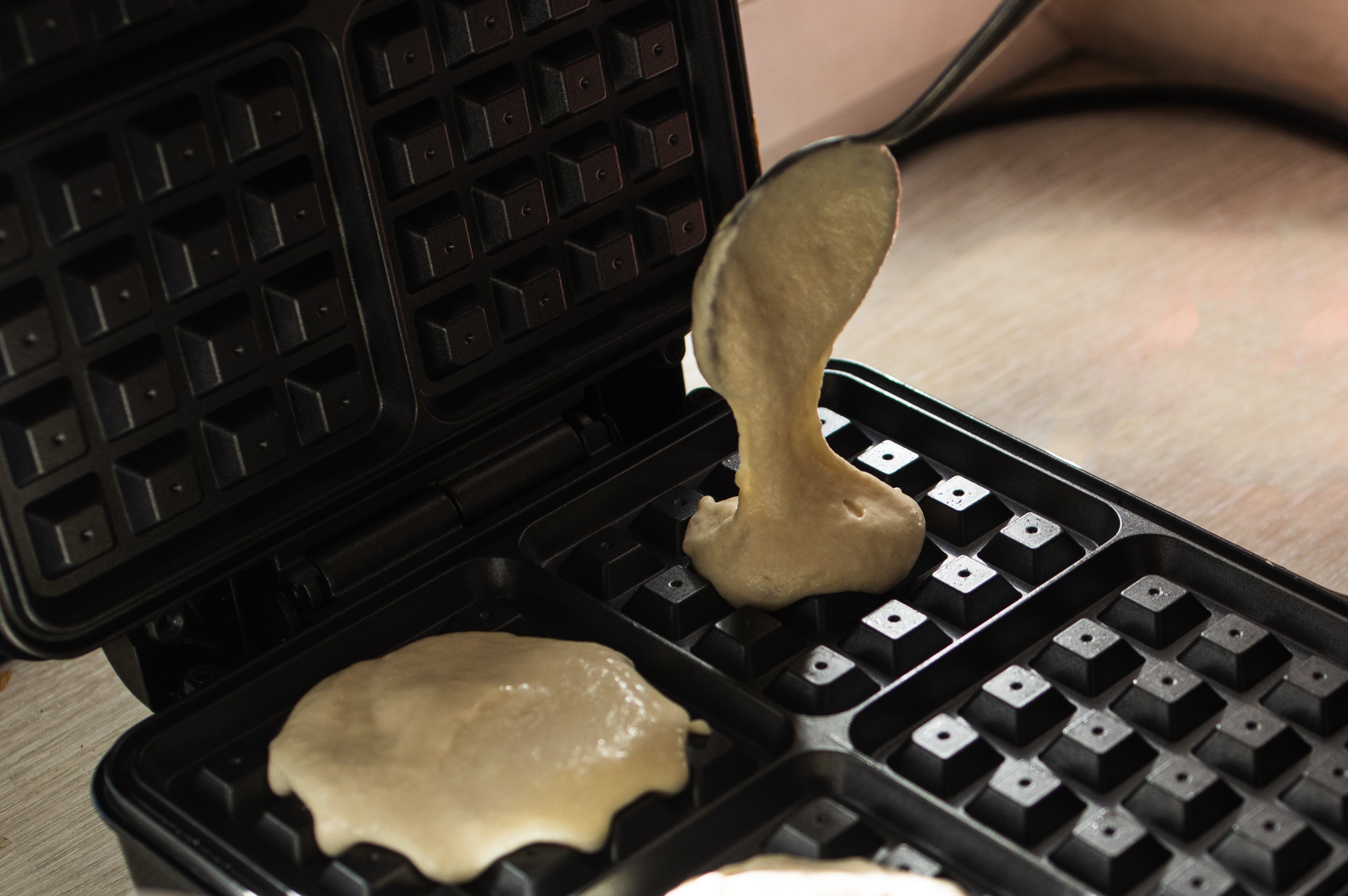 Cooking Belgian waffles in a waffle iron.