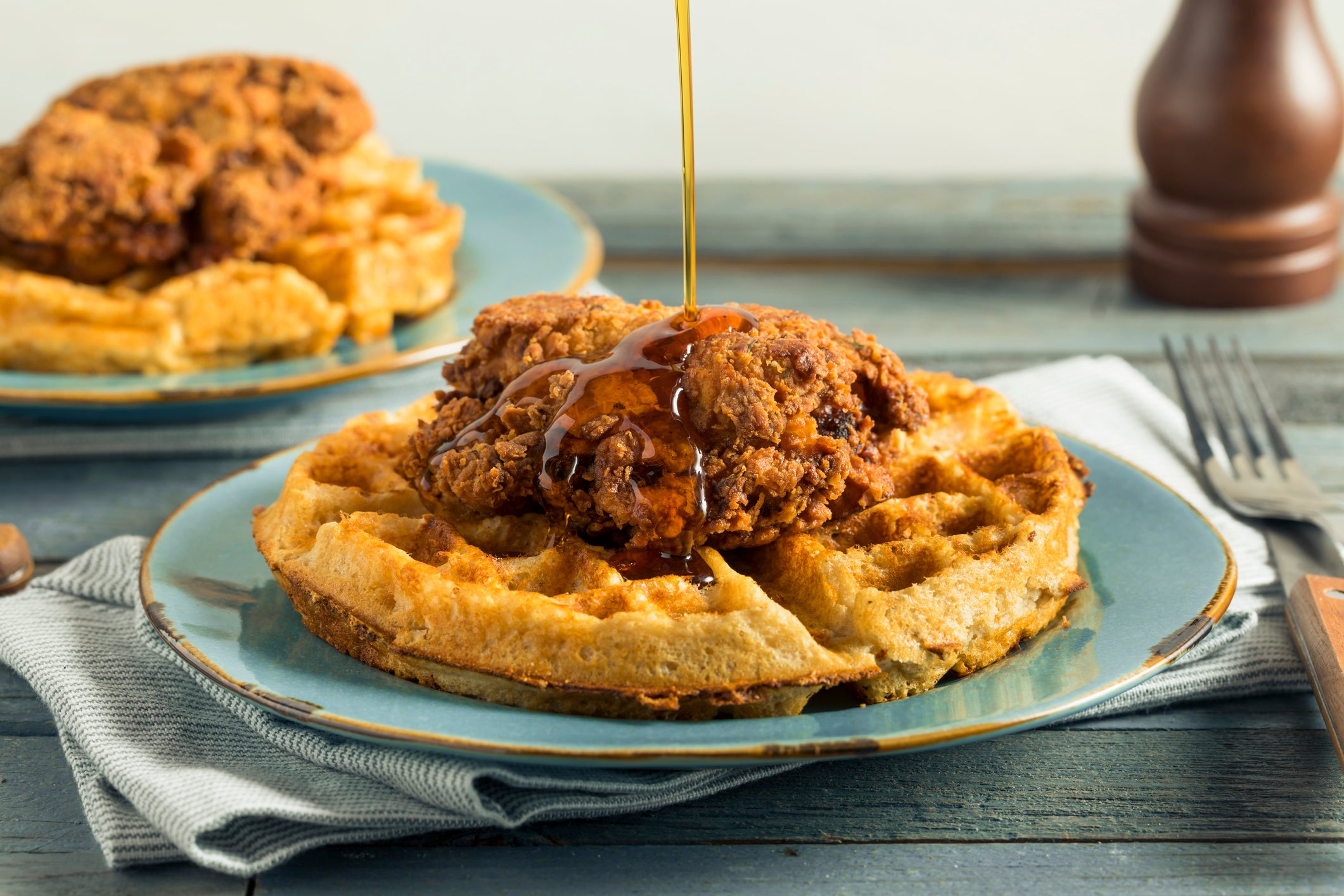 Homemade southern chicken and waffles with syrup.