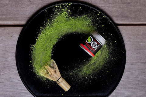 DōMatcha powder on black Japanese plate with tin and bamboo whisk